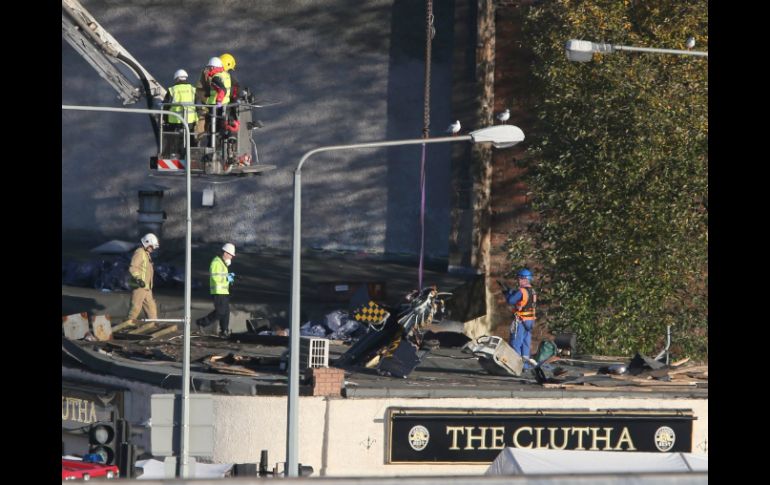 Una grúa levanta pieza por pieza el helicóptero incrustado en el pub The Clutha. EFE /