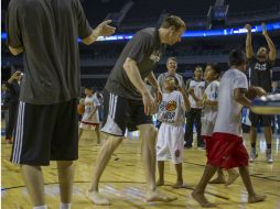 Jugadores de Spurs juegan con los pequeñines indígenas. AP /