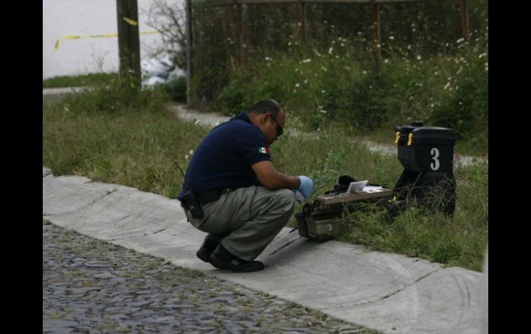 Peritos del estado realizan las investigaciones correspondientes para dar con los responsables del asesinato. ARCHIVO /