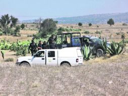 Federales y personal especializado vigilan que nadie se acerque al lugar del hallazgo, en Hueypoxtla. AP /