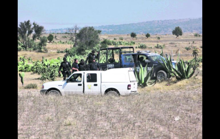 Federales y personal especializado vigilan que nadie se acerque al lugar del hallazgo, en Hueypoxtla. AP /