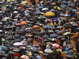 La lluvia se hizo presente en el estadio Soccer City, pero los miles de asistentes no dejaron de bailar y cantar en honor a 'Madiba'. AFP /