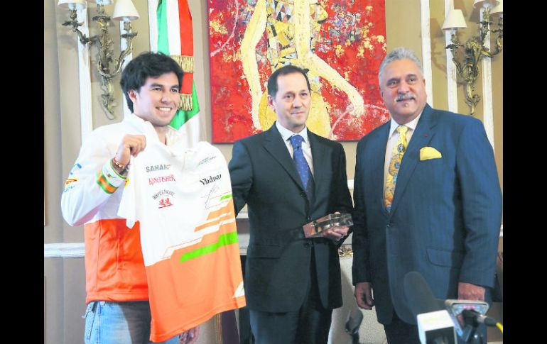 Checo entrega una playera de Force India al cónsul de México en el Reino Unido, tras ser presentado como piloto de la escudería.  /