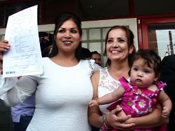 Zaira Viridiana de la O Gómez y Martha Sandoval Blanco, ambas vestidas de blanco, con su hija Sabina en brazos.  /