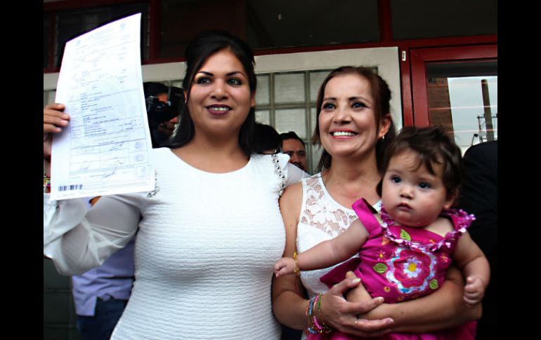 Zaira Viridiana de la O Gómez y Martha Sandoval Blanco, ambas vestidas de blanco, con su hija Sabina en brazos.  /