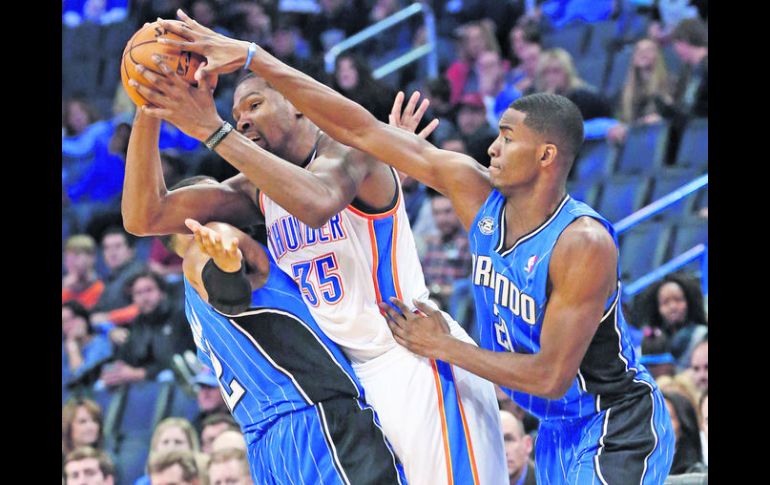 Kevin Durant recibe una falta por parte de Tobias Harris (izq.) y de Maurice Harkless. AP /