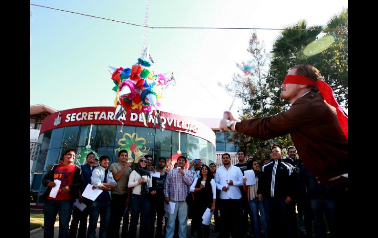 El dirigente de la FEU, José Alberto Galarza Villaseñor, quebra una piñata fuera de la Secretaría de Movilidad.  /