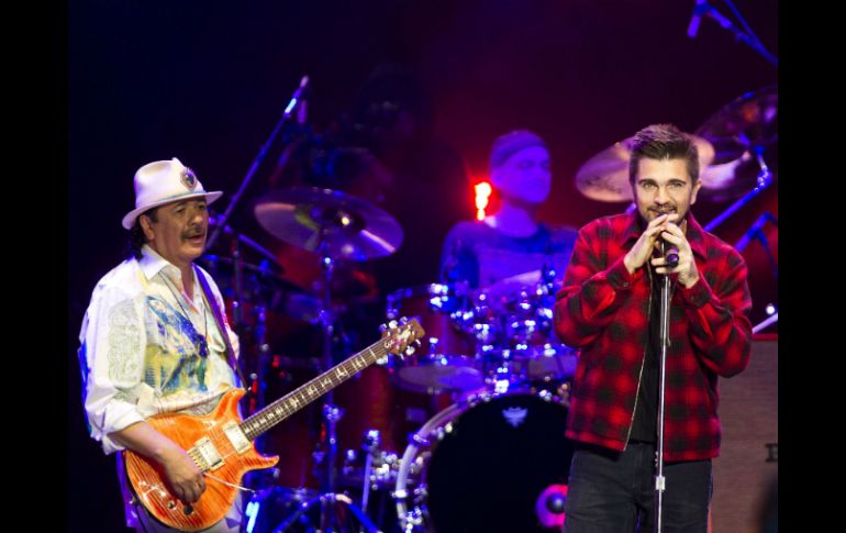 Los cantantes Juanes (d) y Carlos Santana durante un concierto en México. AFP /