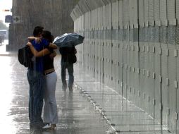 Una pareja se abraza bajo la lluvia. ARCHIVO /