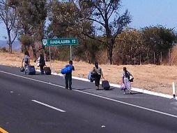 Pasajeros de autobuses decidieron caminar con sus maletas en busca de otro transporte para llegar a su destino.  /