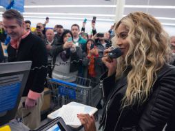 La cantante toma un micrófono para desearles felices fiestas a los presentes.Tomada del facebook de Beyoncé. ESPECIAL /