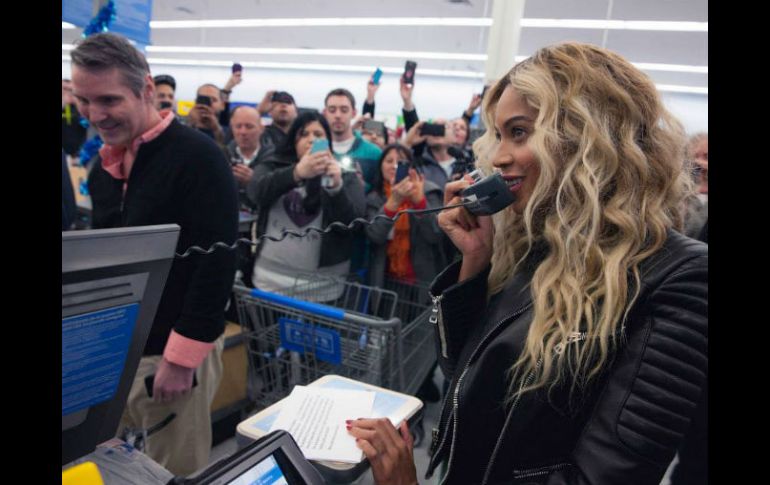 La cantante toma un micrófono para desearles felices fiestas a los presentes.Tomada del facebook de Beyoncé. ESPECIAL /