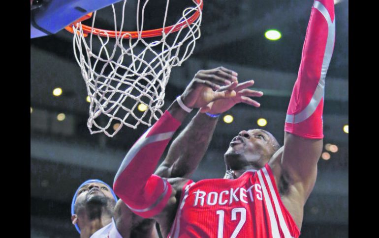 Dwight Howard anota dos puntos ante la marcación de Josh Smith. AP /