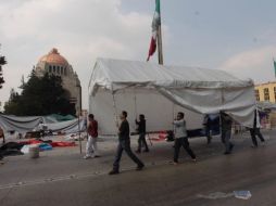 Maestros de la coordinadora desplazan una de sus carpas hacia el interior de la explanada del monumento. SUN /