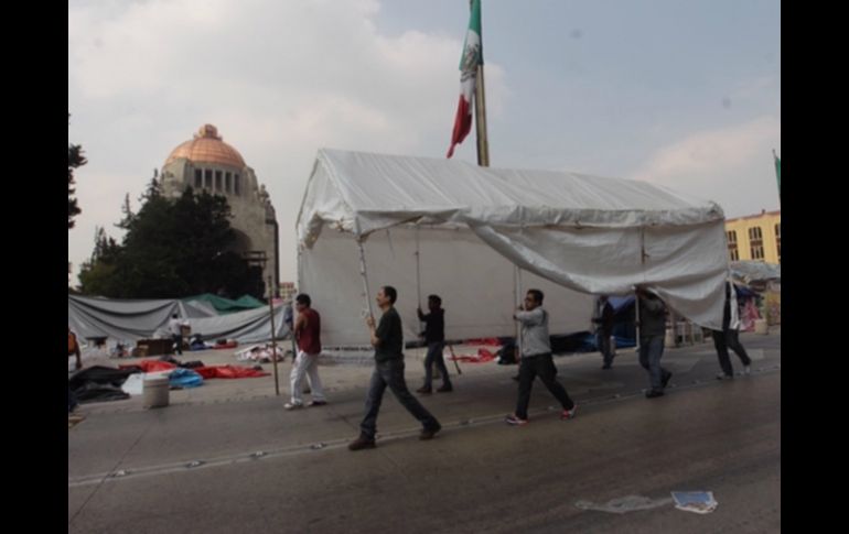 Maestros de la coordinadora desplazan una de sus carpas hacia el interior de la explanada del monumento. SUN /