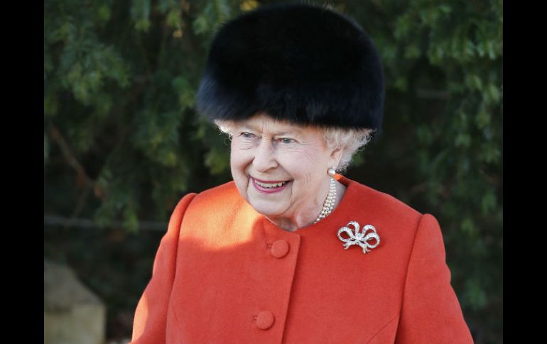 Con un abrigo naranja y un gorro de piel negra, la reina llegó a la ceremonia religiosa en la iglesia St. Mary. AP /