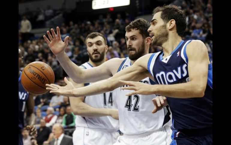 Jose Calderon de Mavericks (d) pierde el pase ante Kevin Love (c) de Timberwolves, durante el partido. AP /