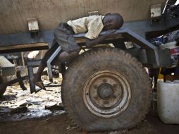 Un niño desplazado descansa en una llanta de una camión contenedor de agua, cientos de personas han perdido sus hogares. ARCHIVO /