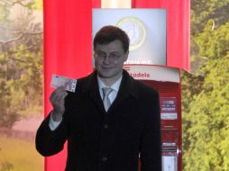 El primer ministro Valdis Dombrovskis muestra el primer euro en circulación en Letonia. AP /