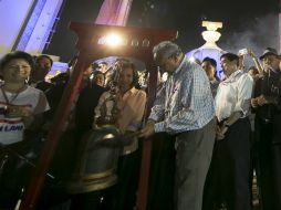 El líder de las protestas, Suthep Thaugsuban, toca una campana por la entrada del 2014. AP /