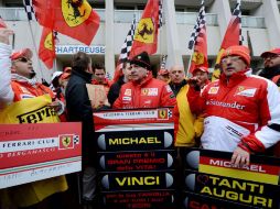 Fanáticos del campeón de Fórmula 1, Michael Schumacher, sostienen pancartas y banderas frente del hospital en el que se encuentra. AFP /