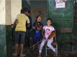 Unas niñas de la orquesta de Cateura, ensayan con sus violines en el interior de una escuela en la barriada de Asunción. EFE /