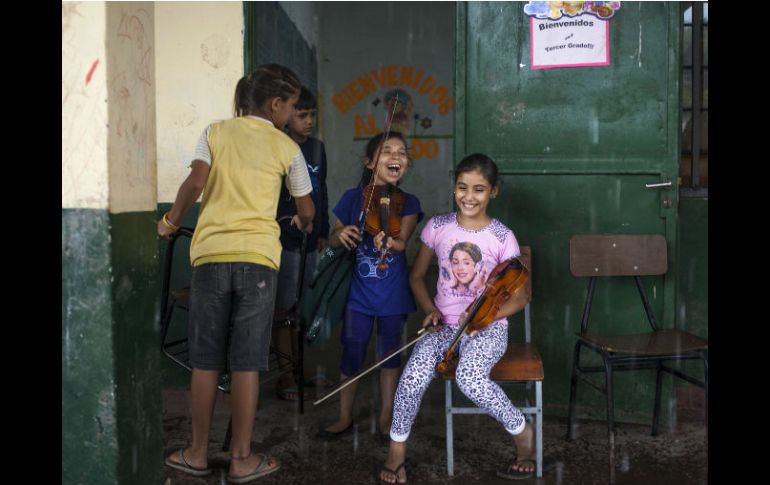 Unas niñas de la orquesta de Cateura, ensayan con sus violines en el interior de una escuela en la barriada de Asunción. EFE /