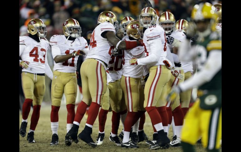 Los jugadores de San Francisco se reúnen en torno a Phil Dawson, después de haber conseguido el gol de campo de la victoria. AP /