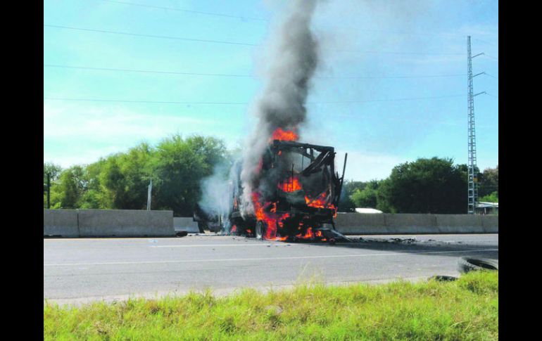 Un camión de pasajeros arde en llamas en una carretera cercana a Parácuaro, Michoacán. AP /
