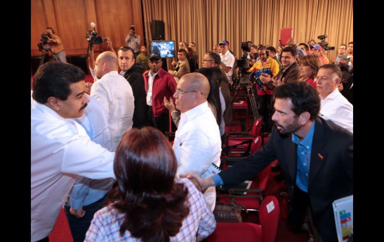 Maduro estrecha la mano con Capriles en una reunión en la que tomaron parte alcaldes y gobernadores. AFP /
