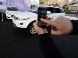 Un hombre usa su smartphone para estacionar un auto. AFP /