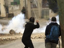 Manifestantes palestinos lanzan piedras a soldados israelíes durante una protesta contra el asentamiento judío de Qadomem. ARCHIVO /