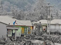 Habitantes de Sumatra limpian los techos de sus casas de las cenizas expulsadas por el volcán. AP /