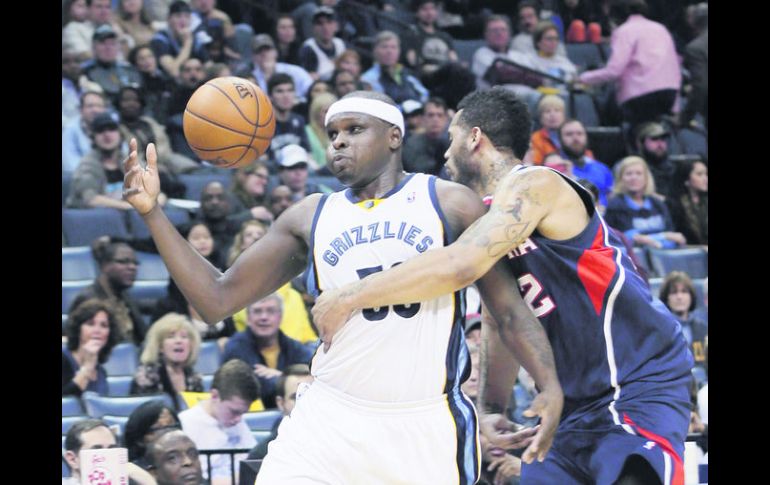 Zach Randolph recibe una falta de Mike Scott. El delantero de Memphis anotó 18 puntos. AP /