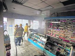 Bomberos sofocan el fuego desatado en una farmacia, cerca de la alcaldía de Apatzingán. Templarios prenden el edificio por la mañana. AP /