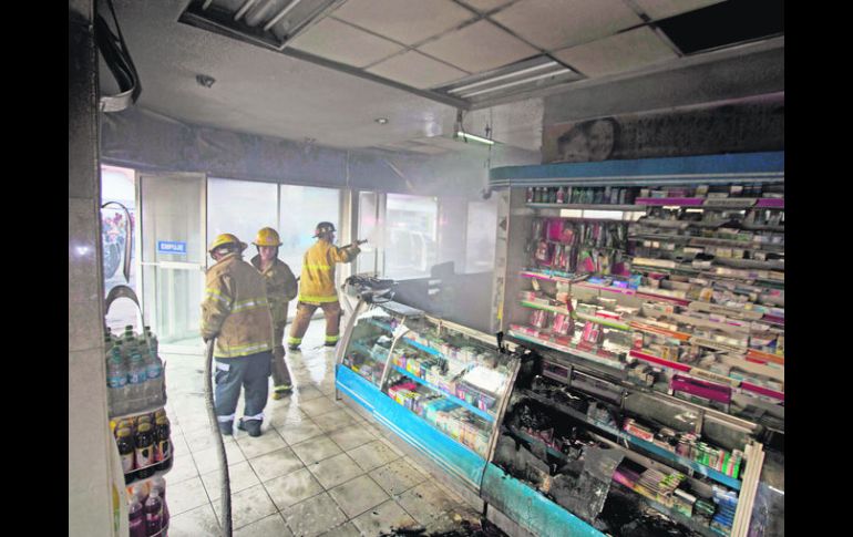 Bomberos sofocan el fuego desatado en una farmacia, cerca de la alcaldía de Apatzingán. Templarios prenden el edificio por la mañana. AP /