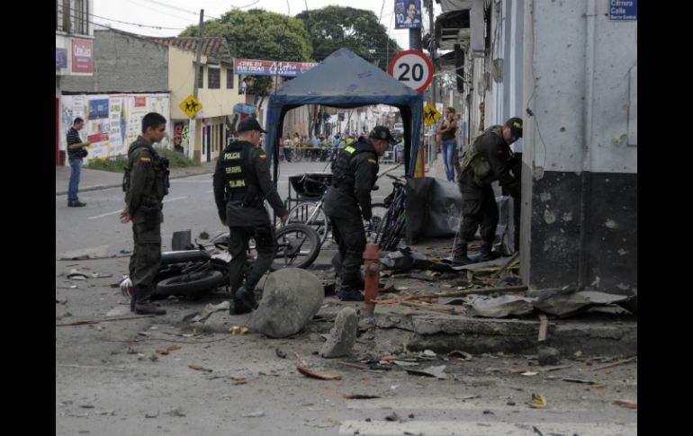 Oficiales de la policía colombiana inspeccionan el lugar donde estalló la motocicleta. AFP /