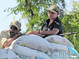 Dos miembros de las autodefensas vigilan el ingreso al poblado de Antúnez desde la barricada que construyeron. EFE /