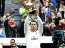 El delantero del Real Madrid Cristiano Ronaldo muestra a la afición, el Balón de Oro a mejor jugador del año que le otorgó la FIFA. EFE /