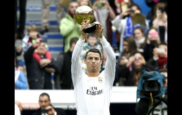 El delantero del Real Madrid Cristiano Ronaldo muestra a la afición, el Balón de Oro a mejor jugador del año que le otorgó la FIFA. EFE /