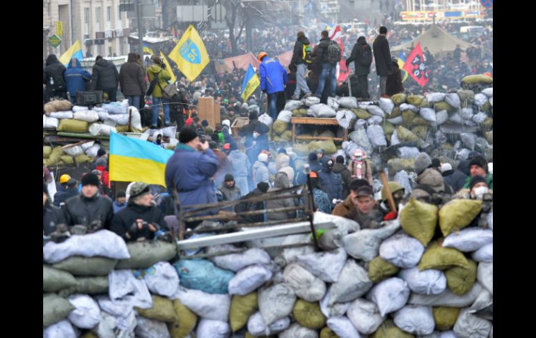 Manifestantes colocan una barricada con costales rellenos con hielo en el centro de Kiev. AFP /
