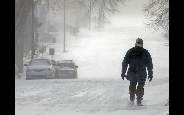 Un hombre camina por una vía nevada en Dakota del Norte. AP /