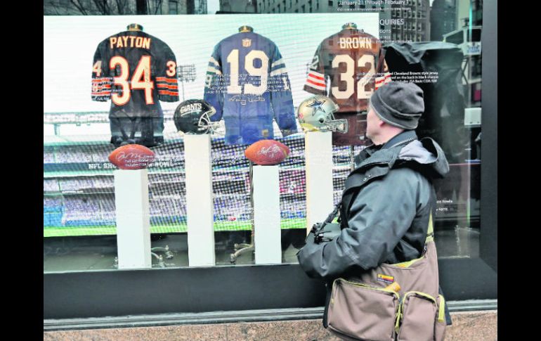 Un aficionado mira un aparador con memorabilia de los jugadores Walter Payton, Johnny Unitas y Jim Brown en Newark. AP /