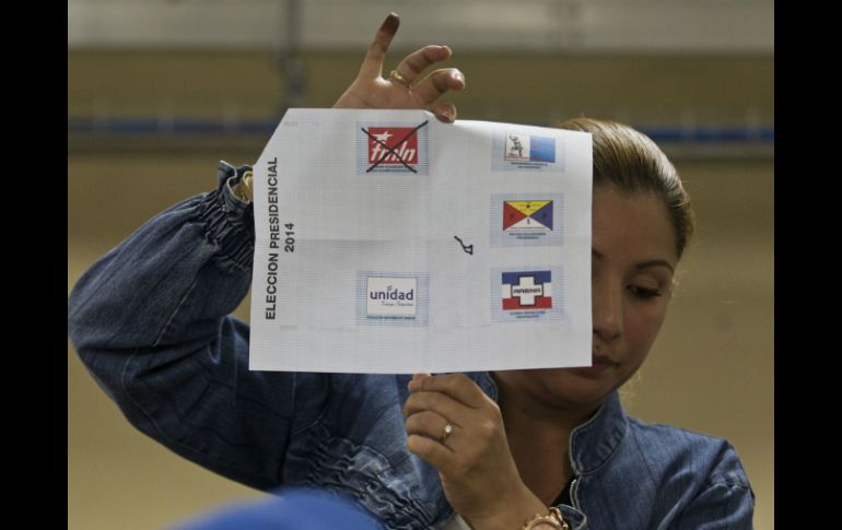 Una oficial muestra un voto durante el conteo de sufragios en el país. AP /