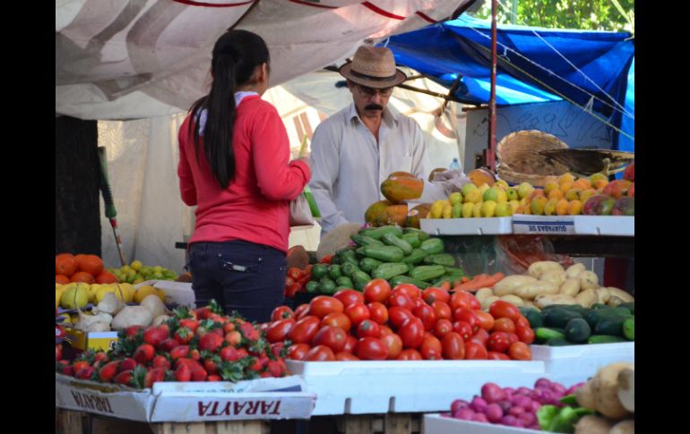 Una mujer acude a hacer sus compras a un puesto de frutas y verduras. ARCHIVO /