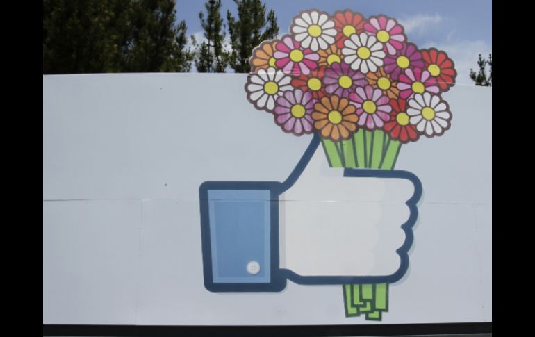 Flores se agregan a una señal de Facebook frente a la sede de la misma. AP /