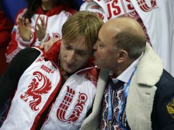 Plushenko es consolado por su entrenador al término de su prueba. AFP /