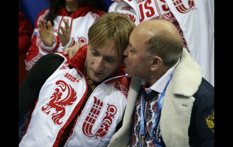 Plushenko es consolado por su entrenador al término de su prueba. AFP /