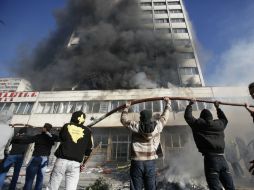 Manifestantes atacando sede presidencial. AP /