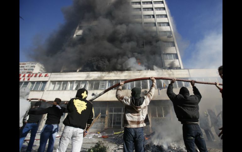 Manifestantes atacando sede presidencial. AP /